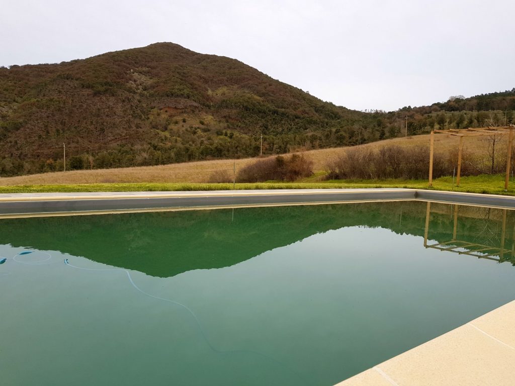Hills reflected in the swimming pool at Villa Le Capanne near Volterra in Tuscany - my review of the perfect big family villa in Tuscany, Italy