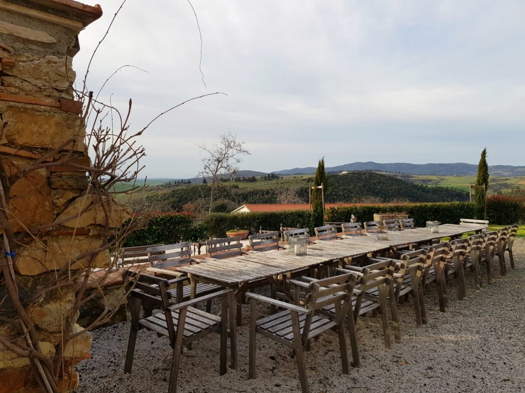 View across the big outdoor table at Villa Le Capanne near Volterra in Tuscany to the countryside - my review of the perfect big family villa in Tuscany, Italy