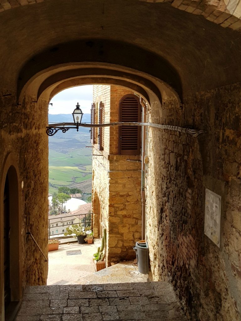 View through an archway to the hills in Volterra near Villa Le Capanne in Tuscany - my review of the perfect big family villa in Tuscany, Italy