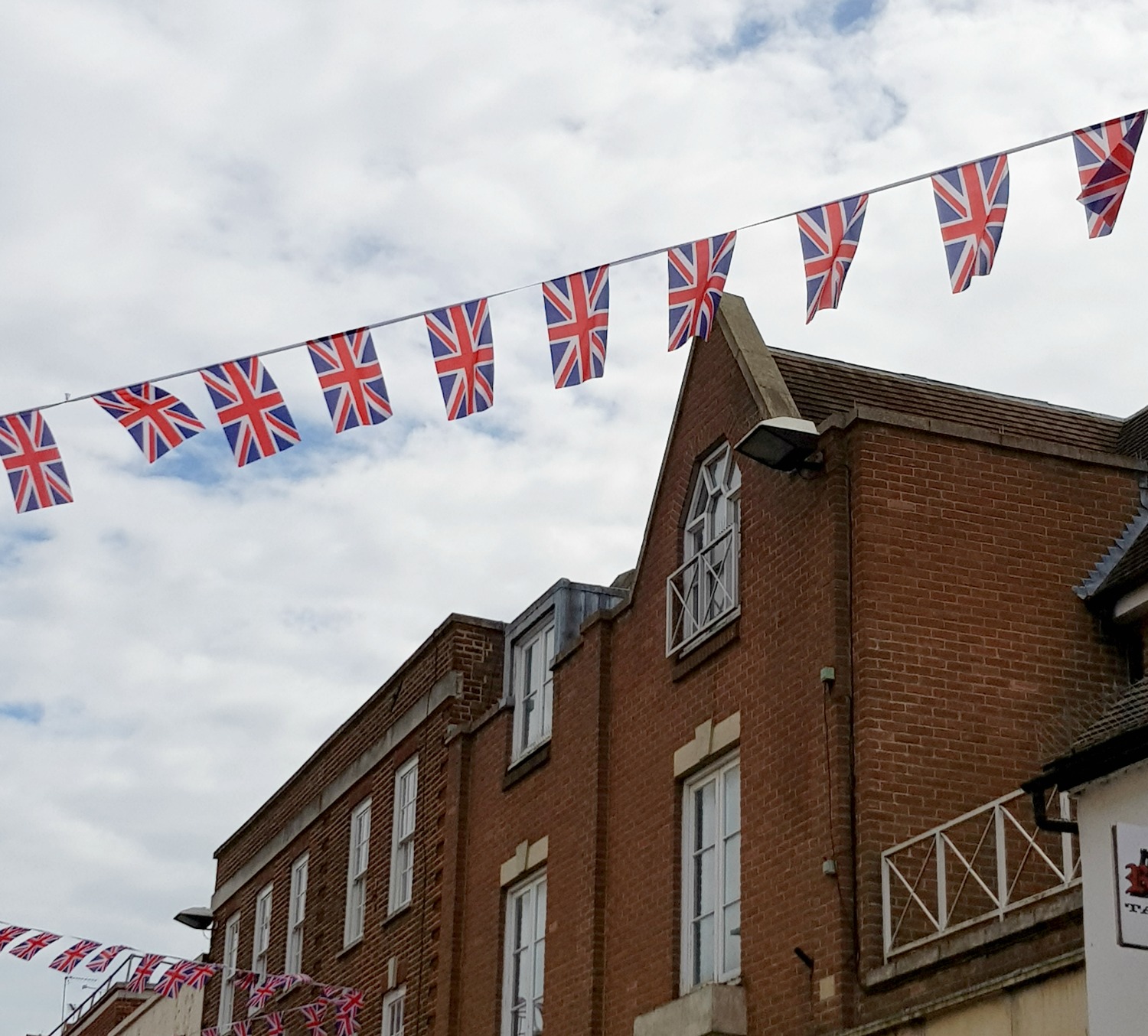 Flag bunting above the shops in Windsor - hopping on to the Windsor original tour, a Windsor bus tour with kids