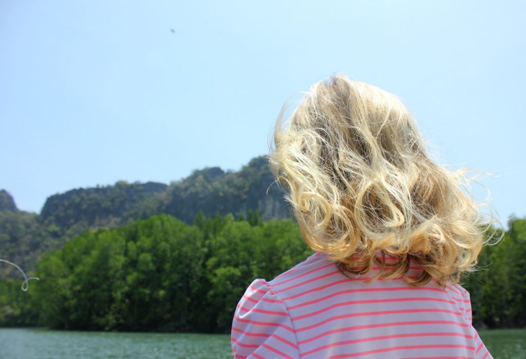 My daughter looks out to the water and scenery as part of a tour through the mangroves - my top Langkawi tour with kids