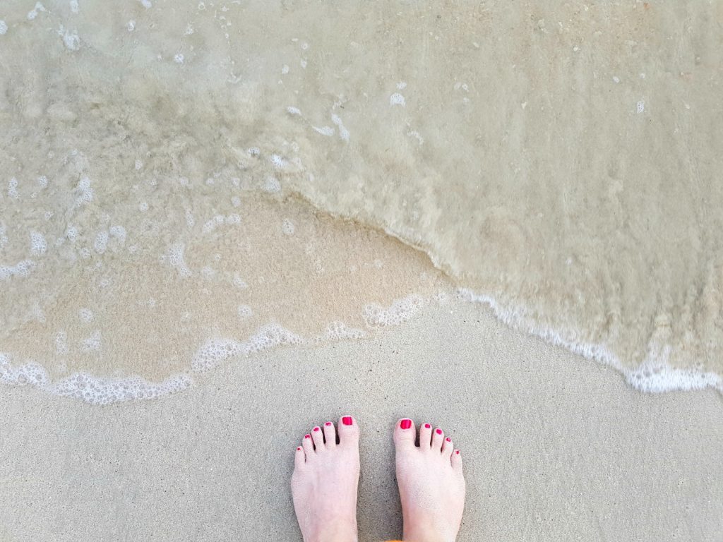 My toes on the white sand by the water's edge on our Langkawi sea safari - my top Langkawi tour with kids