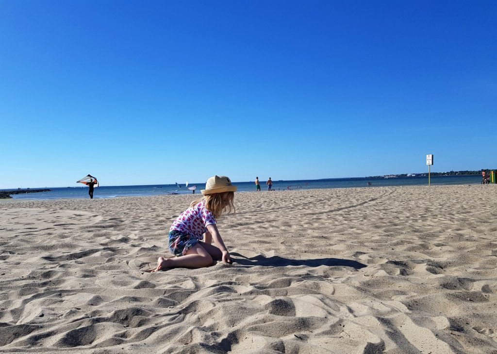 My daughter plays on the sand at Pirita - the beach is just one of the many reasons to visit Tallinn, Estonia