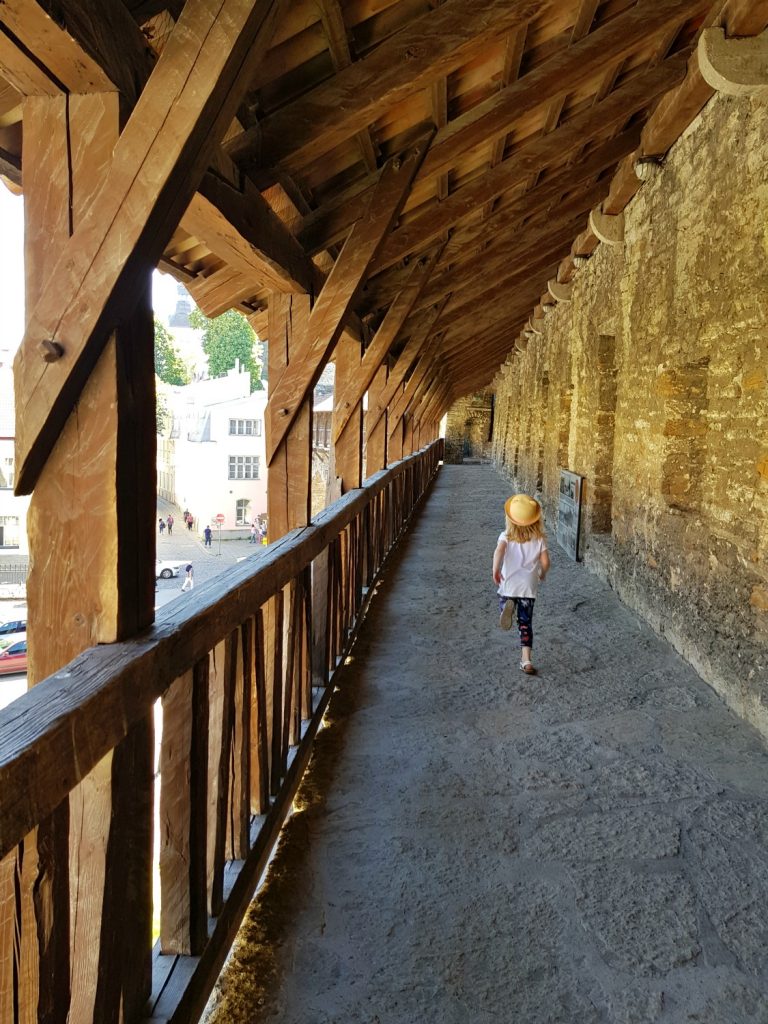 My daughter walks along the old town walls - the city's history is just one of the many reasons to visit Tallinn, Estonia