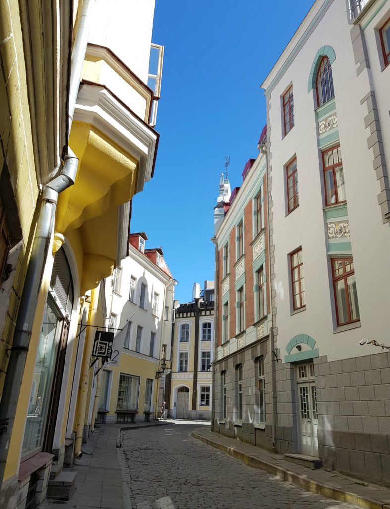 View of pastel and white buildings in an alley in the Old Town - the city's famously fairytale architecture is just one of the many reasons to visit Tallinn, Estonia