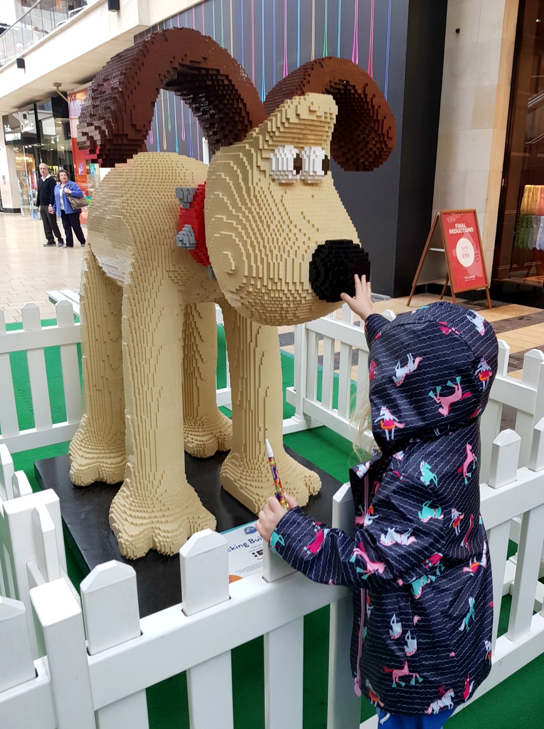 My daughter stretches a hand out towards the Lego version of Gromit - following the Gromit Unleashed 2 trail in Bristol, our review