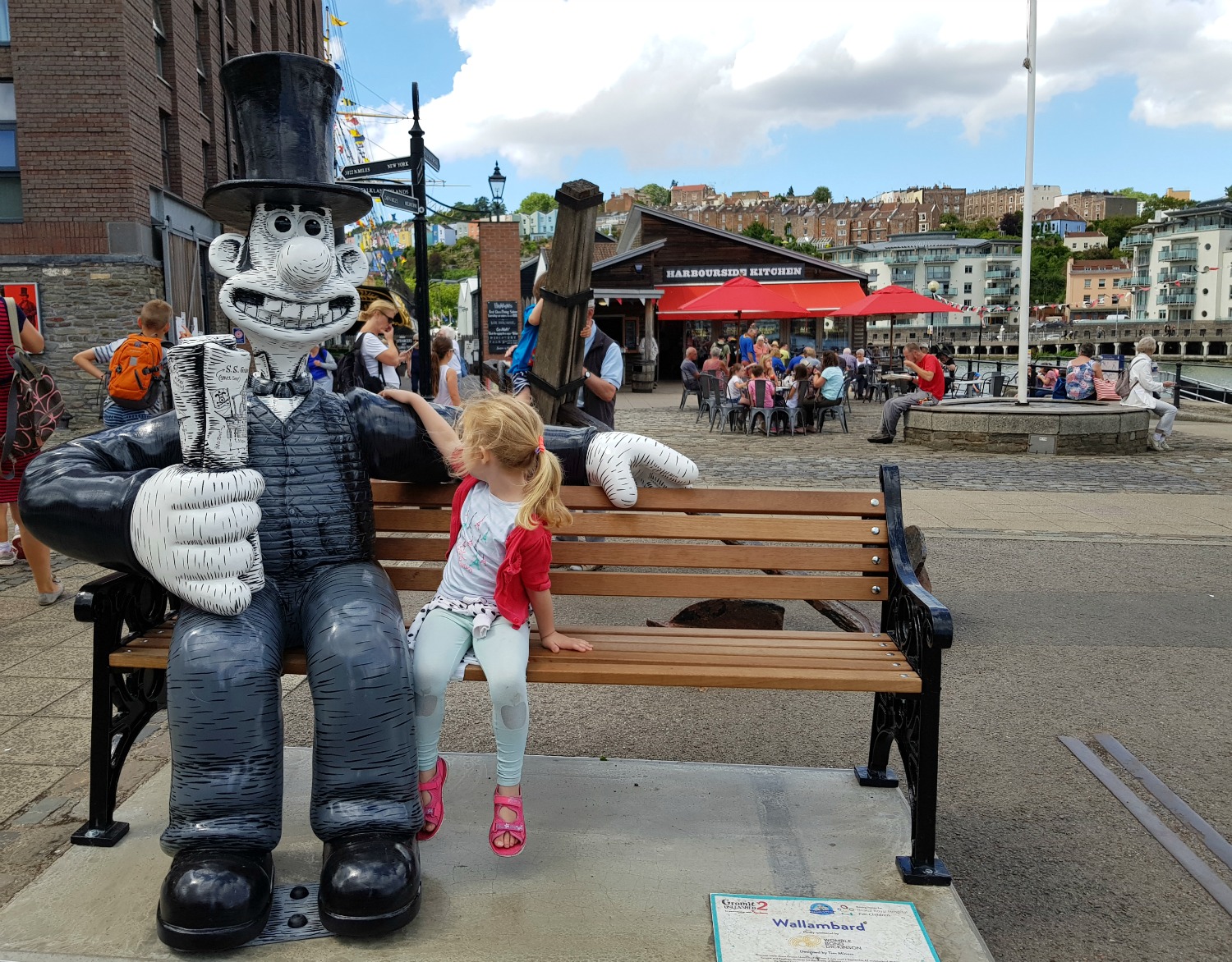 My daughter sits on the bench next to Wallambard near SS Great Britain - following the Gromit Unleashed 2 trail in Bristol, our review