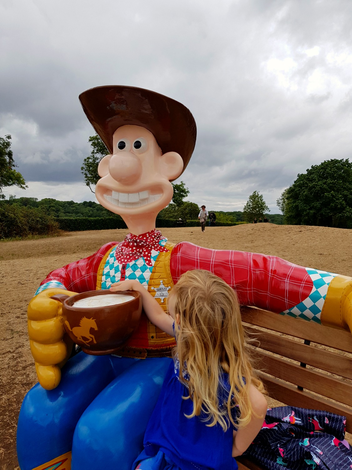 My daughter on a bench with the model of Wallace as the Wensleydale Kid - following the Gromit Unleashed 2 trail in Bristol, our review