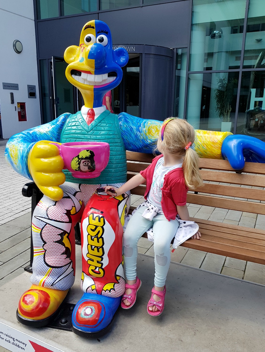My daughter sits next to The Wallace Collection statue, Wallace designed in various artistic styles - following the Gromit Unleashed 2 trail in Bristol, our review