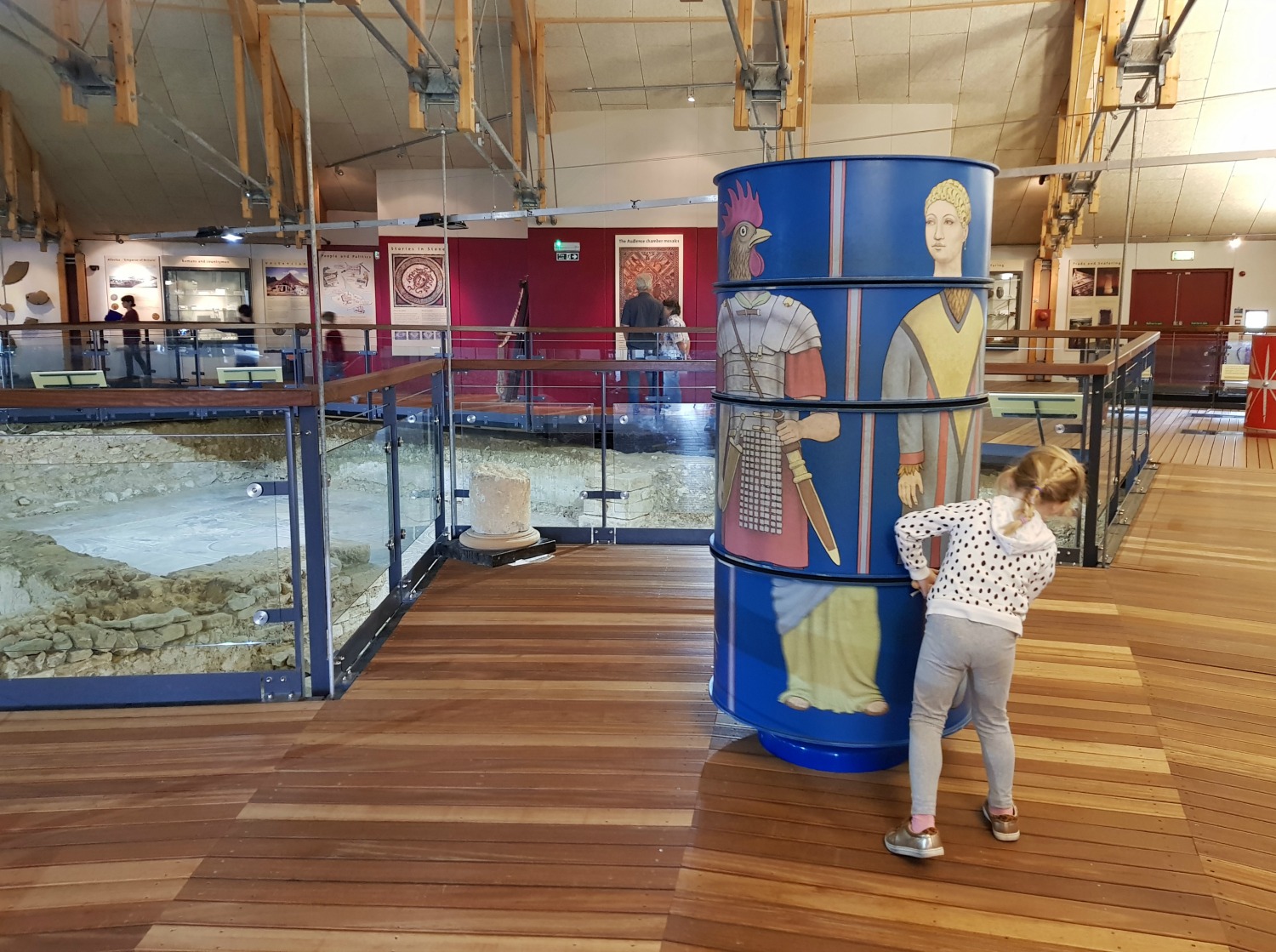 My daughter twirling a huge round exhibit to put Roman heads with bodies at Brading Roman Villa - an Isle of Wight bear hunt, exploring the island in the footsteps of the famous children's book