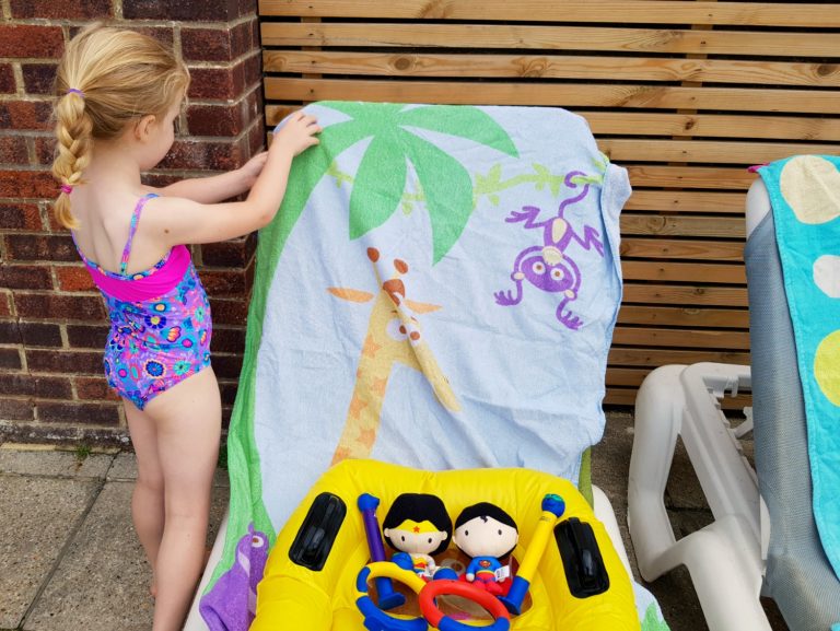 My daughter in her new Zoogs swimming costume with pool toys in the Isle of Wight - my family travel essentials and fun buys for August