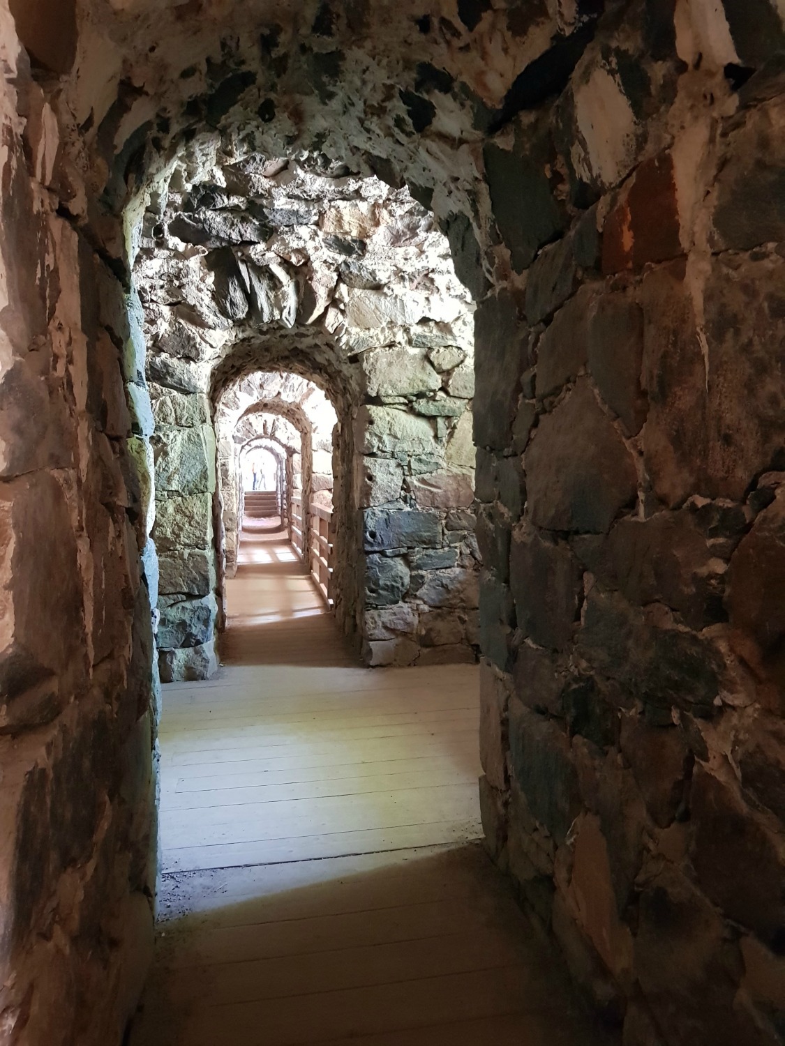 A view through the stone archways of one of the tunnels under Suomenlinna prison and fortress - my tips on visiting Suomenlinna with kids