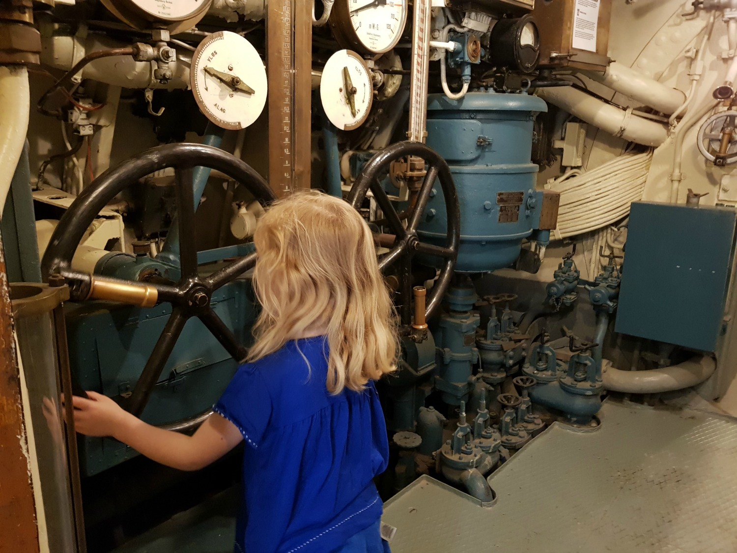 My daughter by the wheel of submarine Vesikko on Suomenlinna island - my tips on visiting Suomenlinna with kids
