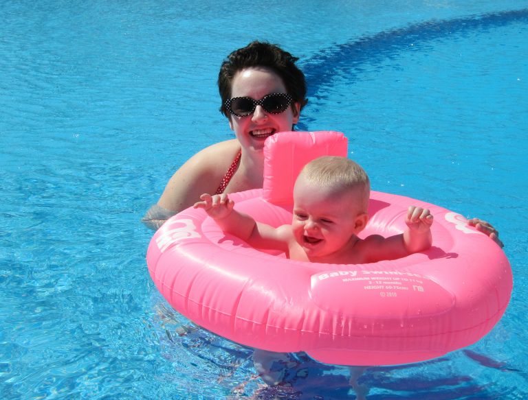 My daughter in a pink inflatable ring in the pool with me on one of our first overseas holidays in Lanzarote - my tips on taking villa holidays with grandparents and why multigenerational villa holidays are great