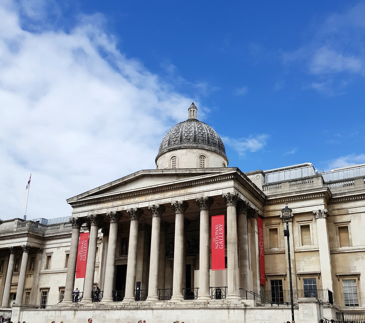 The exterior of the National Gallery in London, seen from Trafalgar Square against a blue sky - one of the many free museums in London for a day out with kids