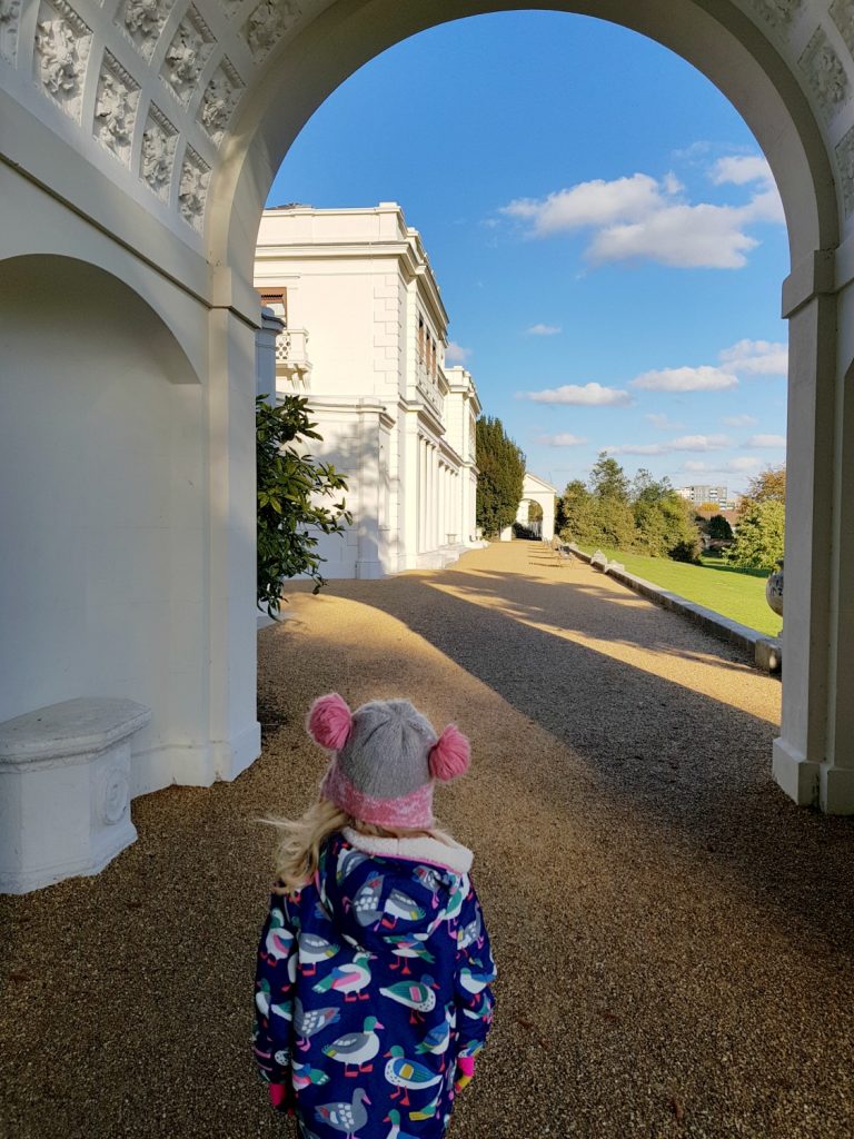 My daughter under the archway leading to the rear of the mansion and terrace - my review of a free day out in London, visiting Gunnersbury Park Museum with kids