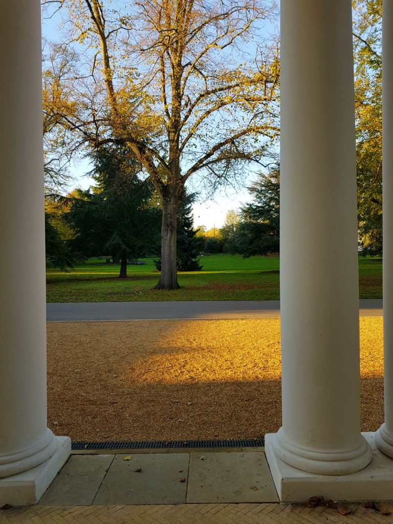 Pillars at the entrance to the museum and former mansion looking out onto the driveway and autumn leaves - my review of a free day out in London, visiting Gunnersbury Park Museum with kids
