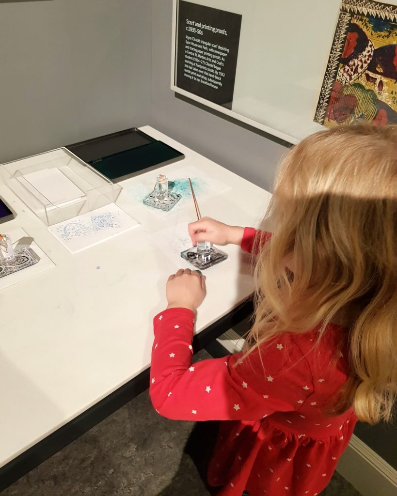 My daughter tries the ink print blocks to make a postcard in the local industry gallery - my review of a free day out in London, visiting Gunnersbury Park Museum with kids
