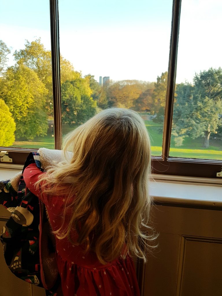 My daughter looks out of the window towards the grounds and horseshoe pond - my review of a free day out in London, visiting Gunnersbury Park Museum with kids