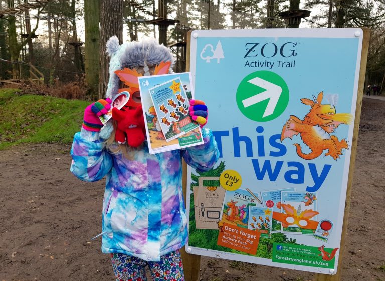 My daughter with dragon and activity sheet at the starting point for the Zog trail at Wendover woods, Buckinghamshire