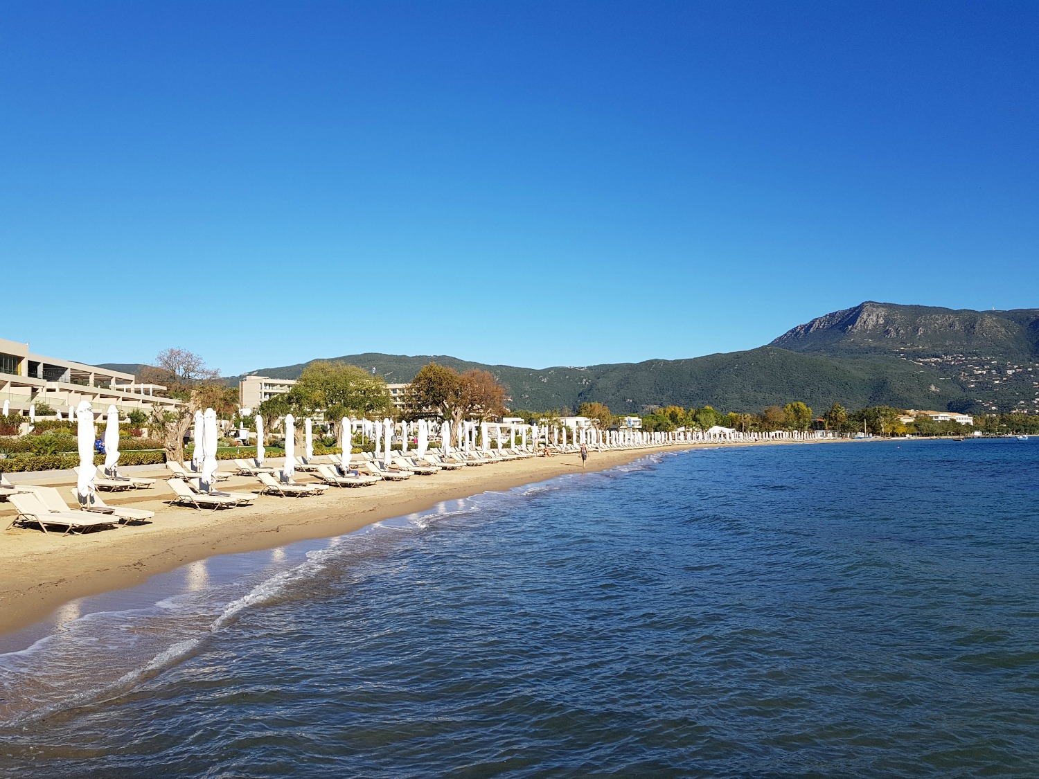 A view across the sea to the beach and hills behind Ikos Dassia - my review of Ikos Dassia with kids, a family holiday in Corfu