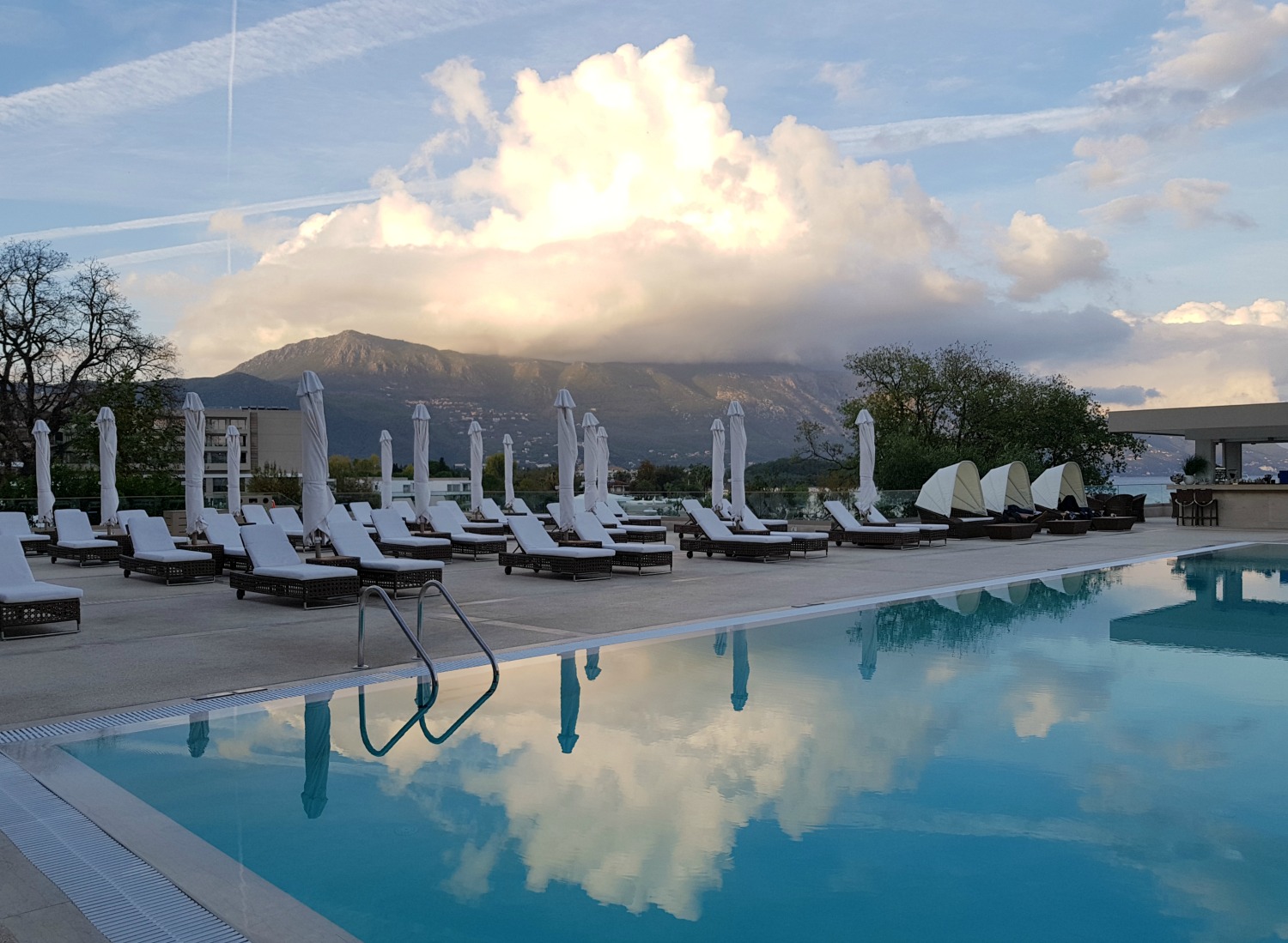 The adults only pool with clouds and hills behind at Sea at Ikos Dassia - my review of Ikos Dassia with kids, a family holiday in Corfu