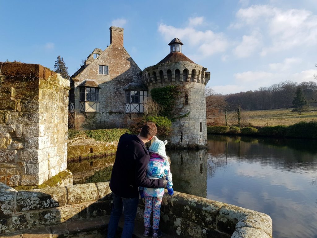 My husband and daughter look out across the moat to the remains of 14th century Scotney Castle, Kent - our winter day out at Scotney Castle with kids