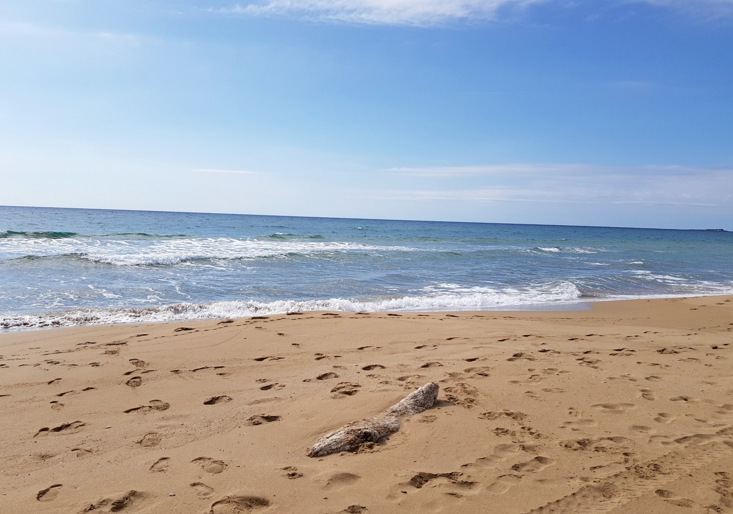 View across the golden sand to the waves on a deserted beach near Agios Georgios south - one day in Corfu exploring some of the island in an Ikos Dassia mini