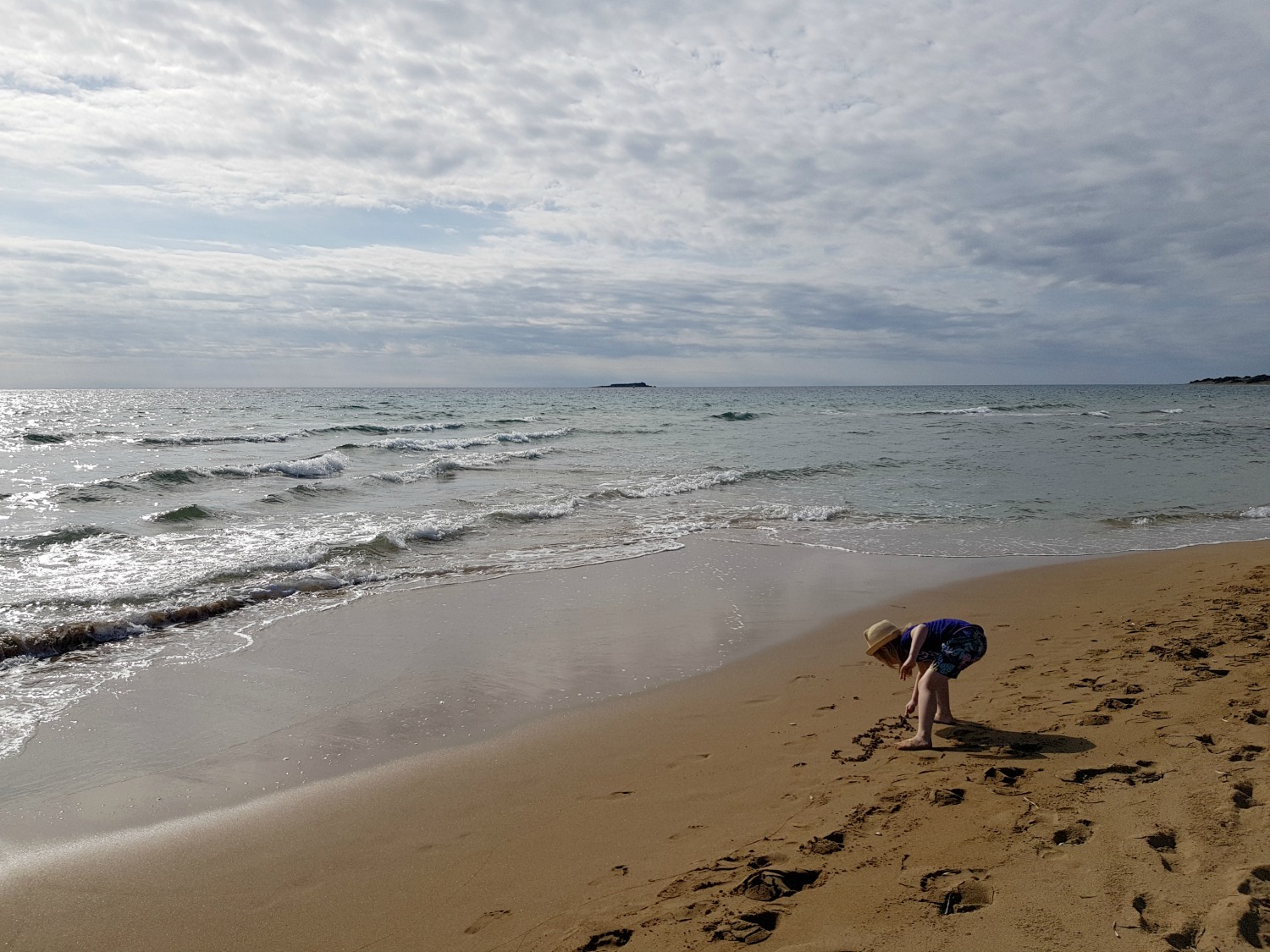My daughter writes in the sand at Issos beach - one day in Corfu exploring some of the island in an Ikos Dassia mini