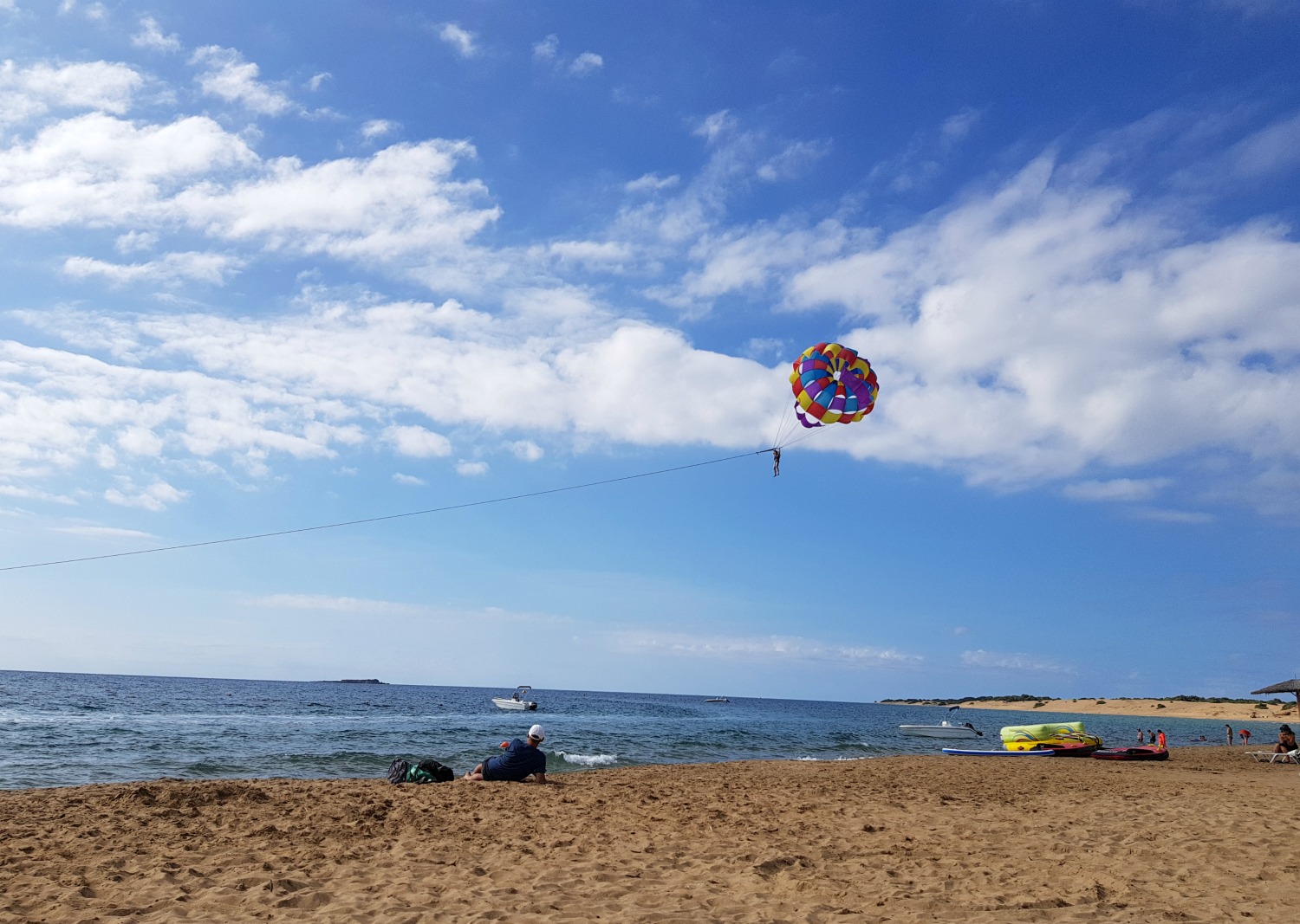Brightly coloured canopy from a parascender over the blue sea at Issos beach - one day in Corfu exploring some of the island in an Ikos Dassia mini