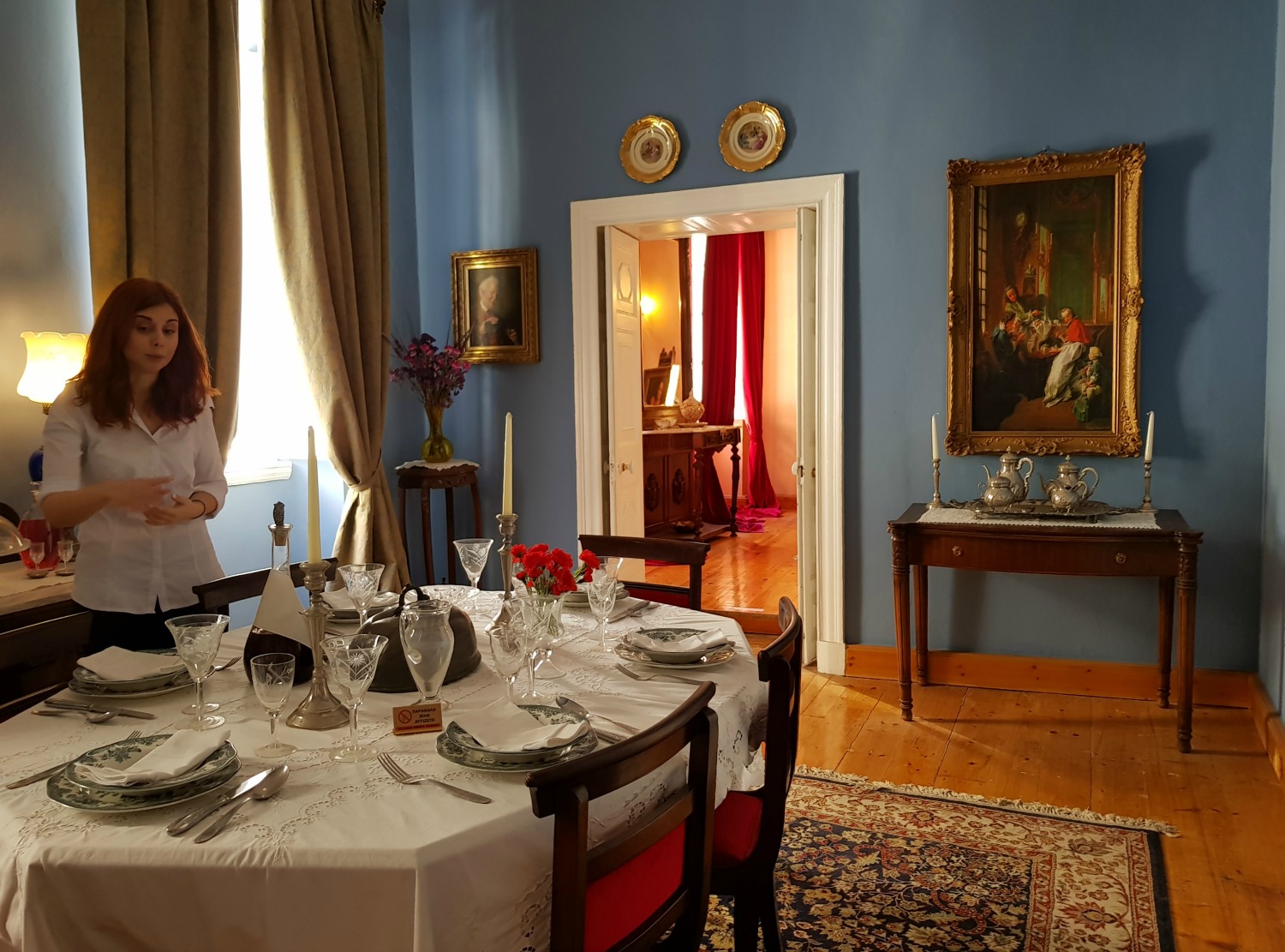 Our guide by the dining table of Casa Parlante, with its crystal and china - one of my three things to do in Corfu Town with kids