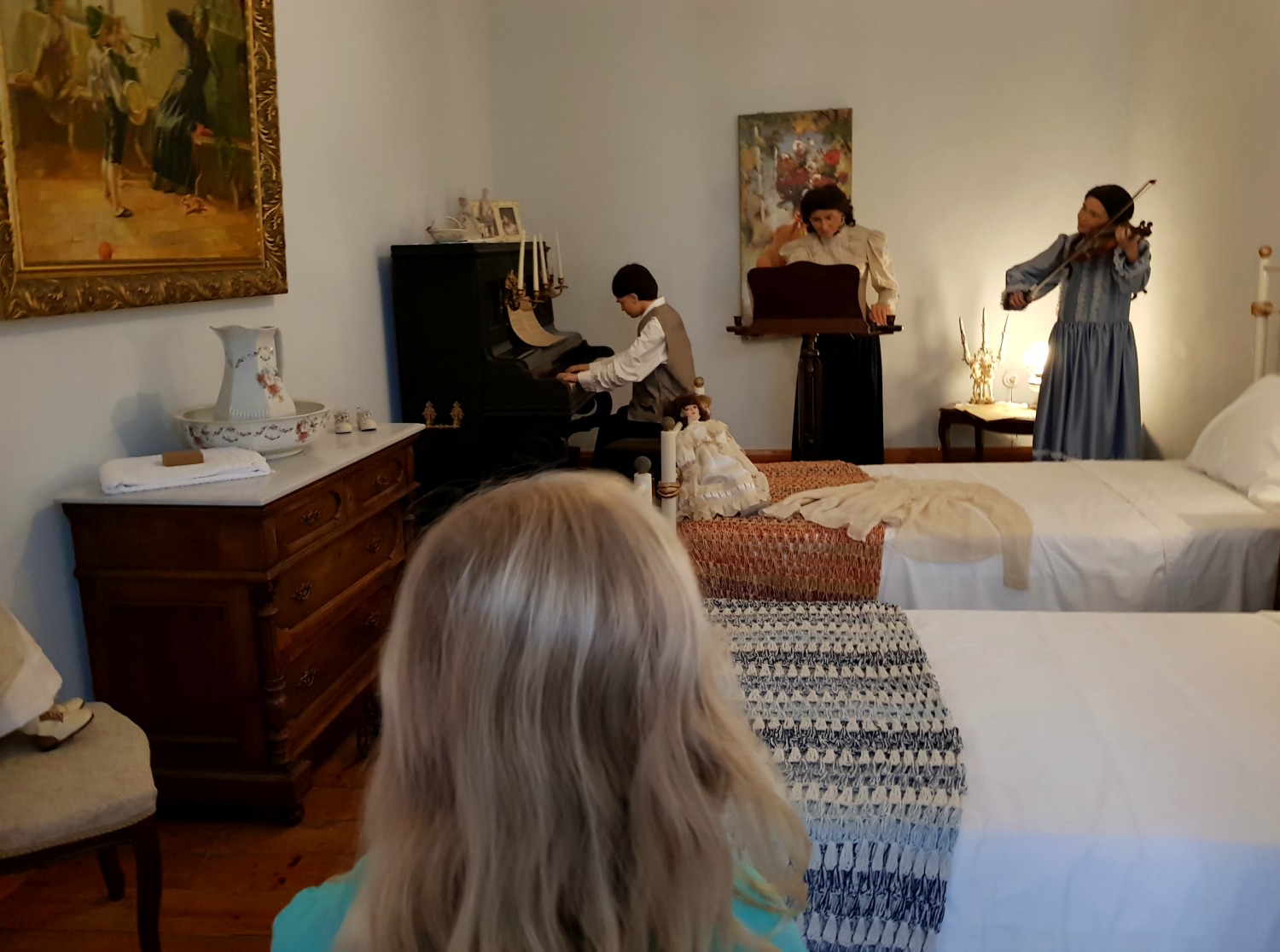 My daughter looks at the waxwork children playing music in their bedroom at Casa Parlante - one of my three things to do in Corfu Town with kids