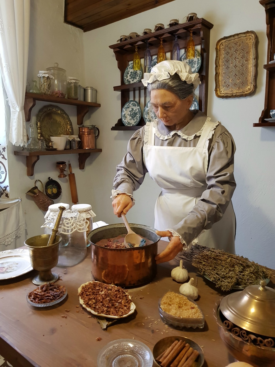 A waxwork of the cook at Casa Parlante in the middle of cooking in the kitchen - one of my three things to do in Corfu Town with kids
