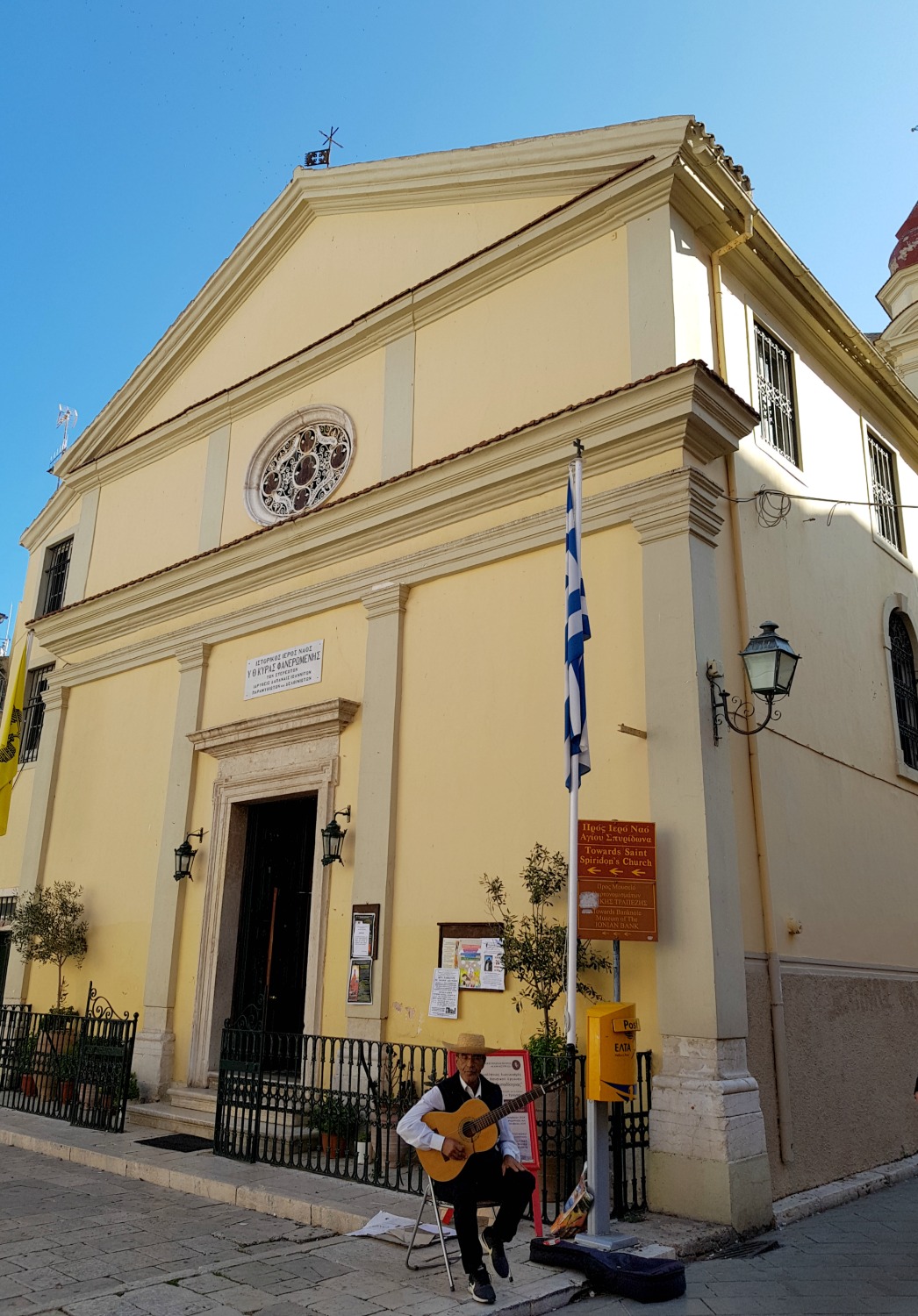 A musician plays outside one of the buildings in the Old town - three things to do in Corfu Town with kids