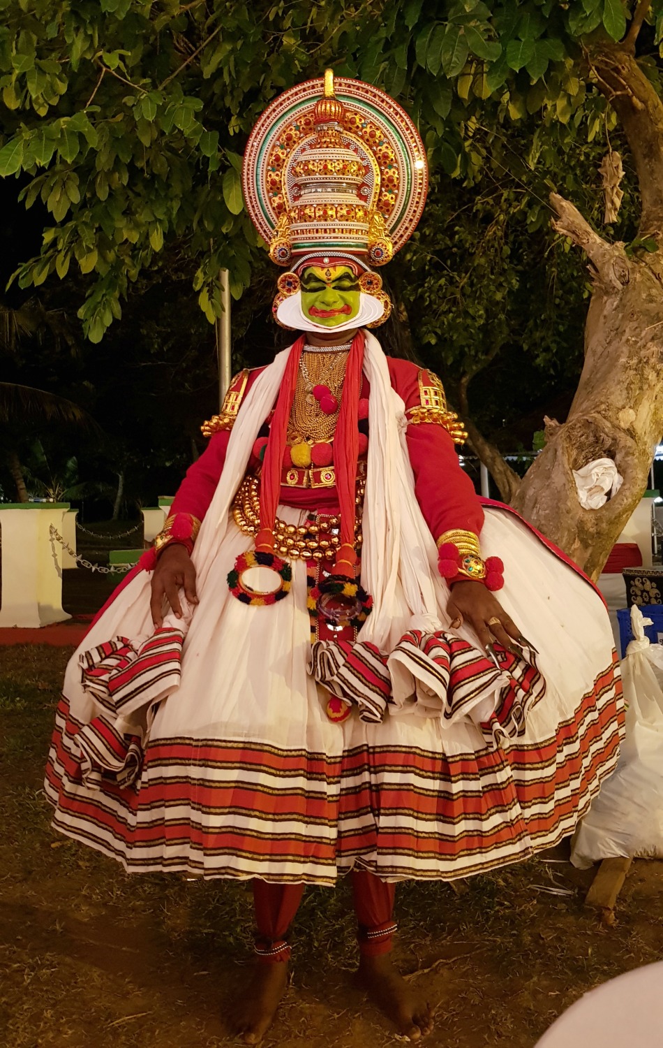Kathakali dancer in full costume with green made-up face after a performance - my one week in Kerala itinerary, including Kerala with kids