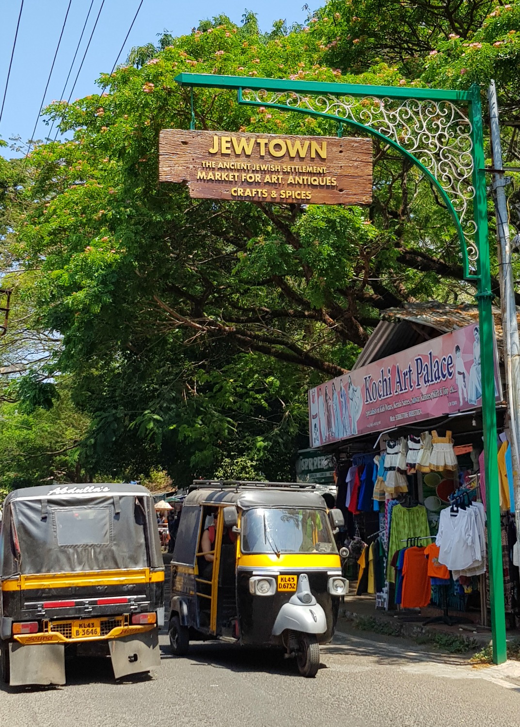 Tuktuks pass in the street under the sign for Jewtown in Mattancherry - my one week in Kerala itinerary, including Kerala with kids