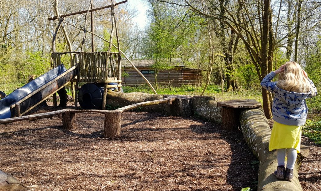 Girl playing in the natural adventure playground at Penhein luxury glamping