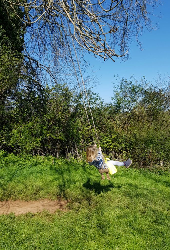 Girl on a tree swing at Penhein - my Penhein glamping review