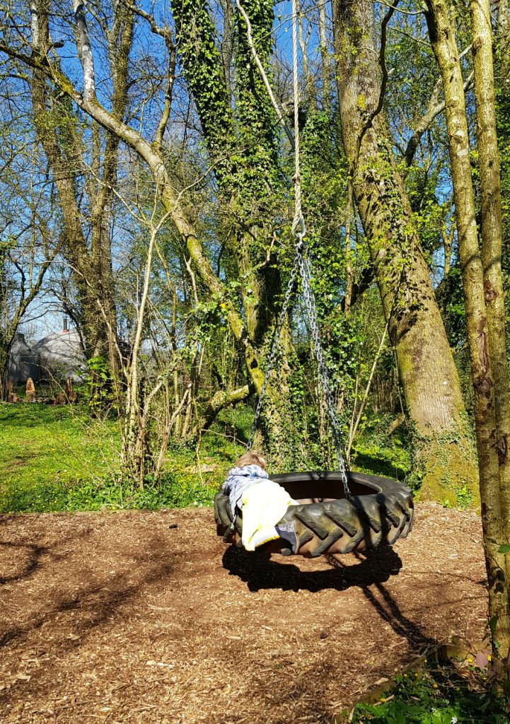 My daughter plays on the tyre swing at Penhein luxury glamping in Wales
