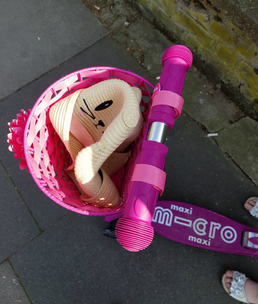 My daughter's Maxi Micro Scooter with basket attached, containing a summer hat