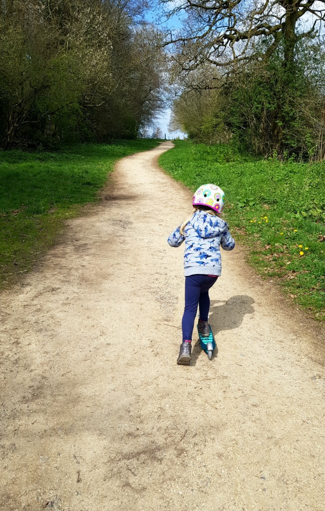 My daughter scoots on her Micro Sprite scooter up a hilly path on the Bath Skyline Family Discovery trail