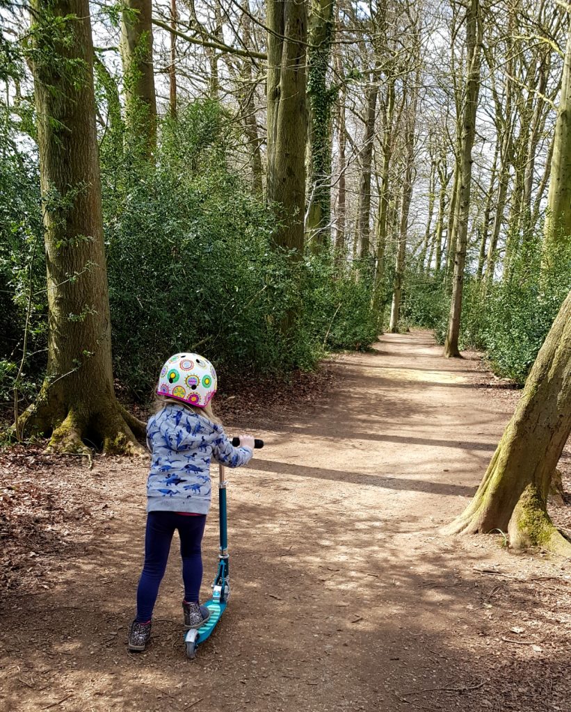 My daughter scoots on her Micro Sprite scooter through a woody path on the Bath Skyline Family Discovery trail