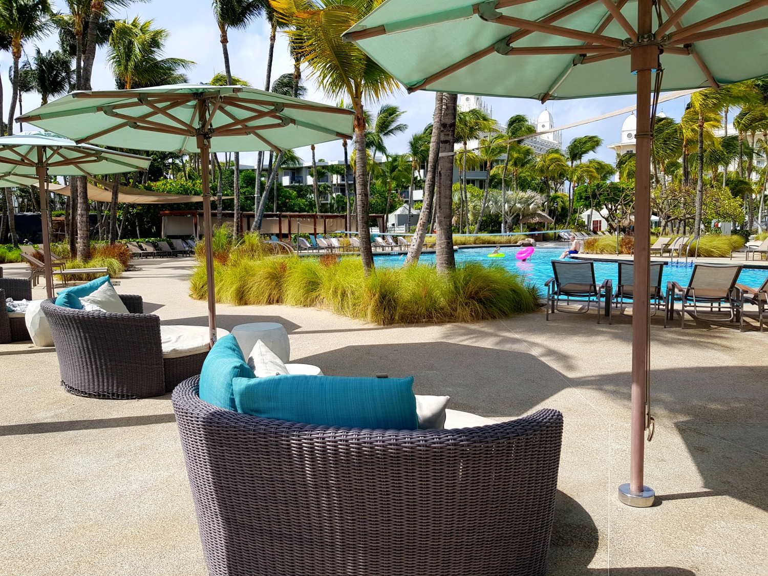 Comfy seats and umbrellas around one of the pools at the Hilton Aruba - my Hilton Aruba review if you're wondering where to stay in Aruba with kids