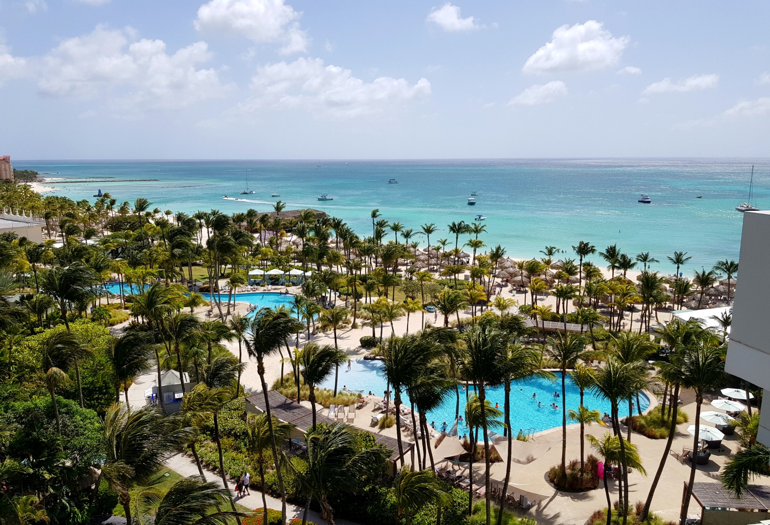View from our balcony at the Hilton Aruba resort across to the pools and the sea - my Hilton Aruba review. Is this the best hotel in Aruba with kids?