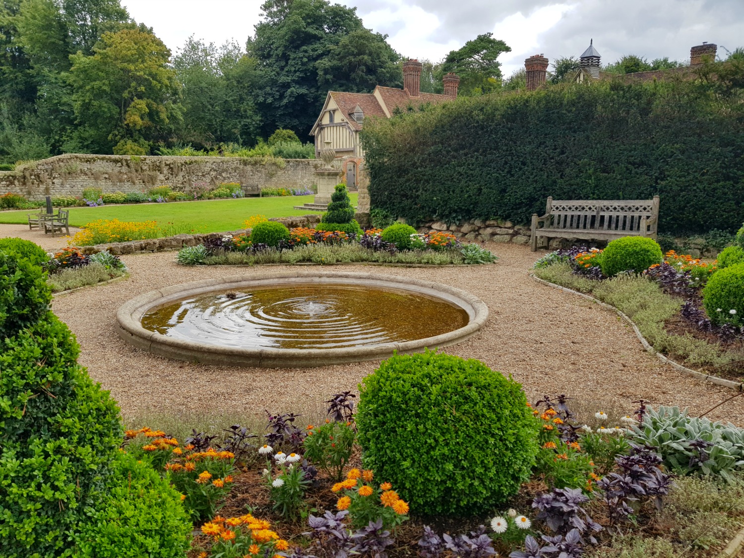 Looking across a pool and gardens to Ightham Mote house in Kent