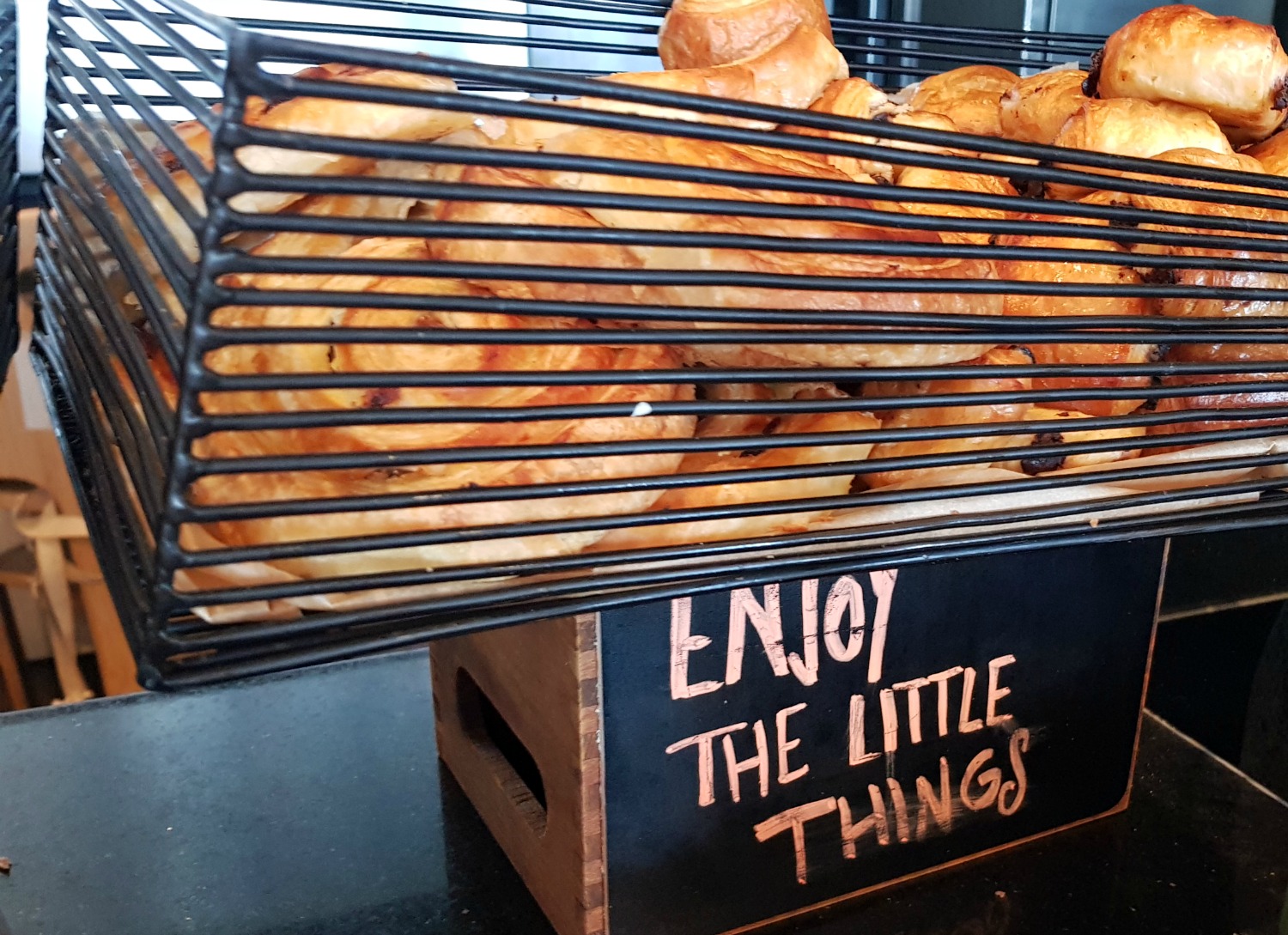 Basket of pastries and croissants with a sign saying Enjoy the Little Things - breakfast at Radisson Blu Birmingham hotel