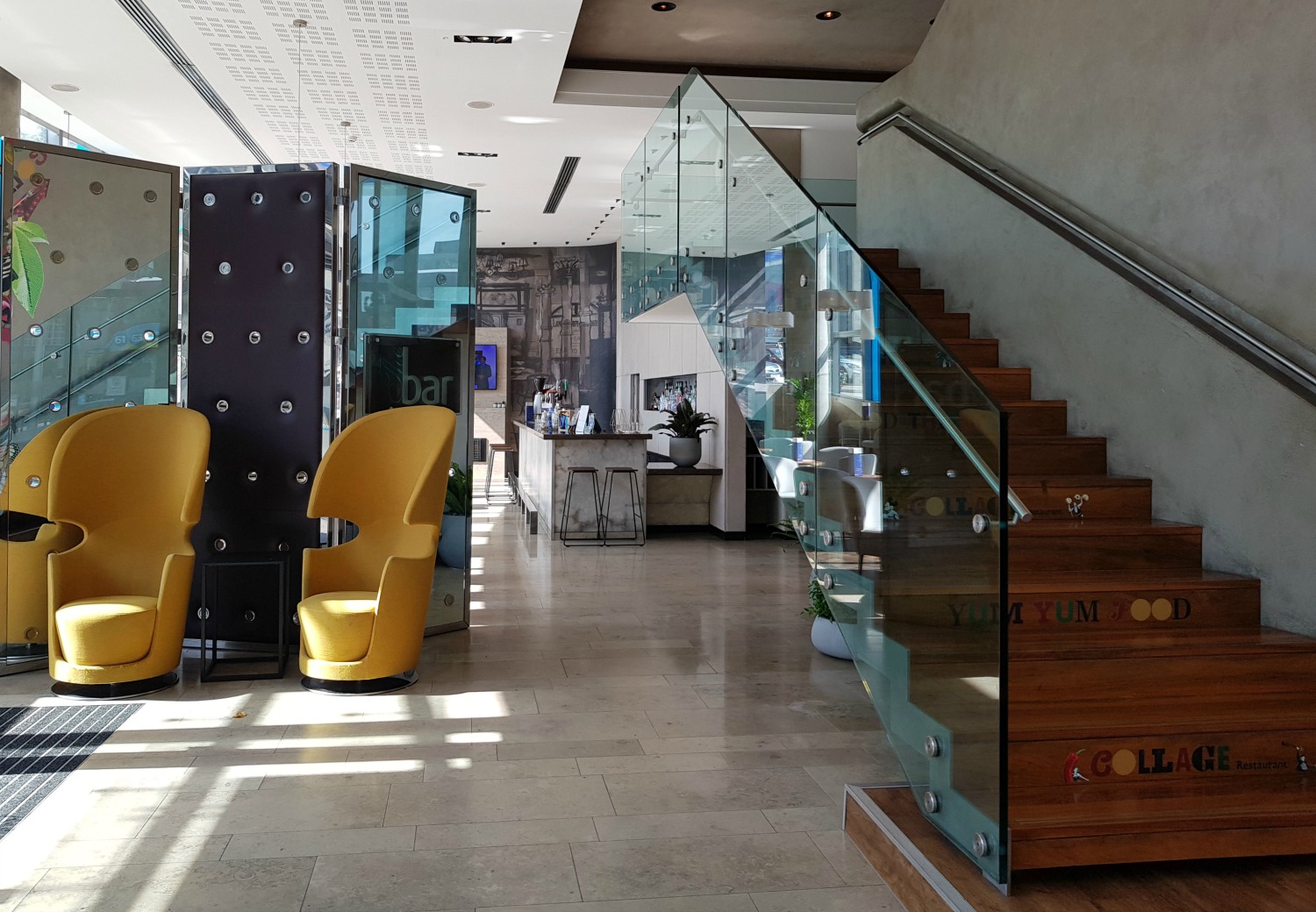 View of the lobby including bright yellow chairs and the bar in the background at Radisson Blu Birmingham hotel - my review