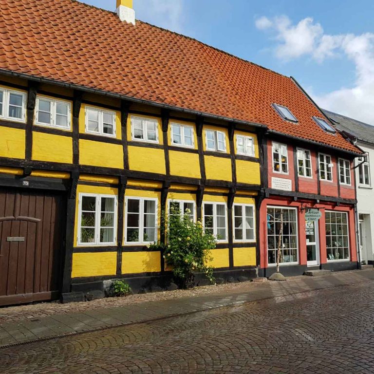 Brightly coloured houses in historic Ribe, one of the many places to discover in Jutland beyond Legoland - my suggestions of what to do during one week in Jutland with kids, including history, Vikings, animals and Lego