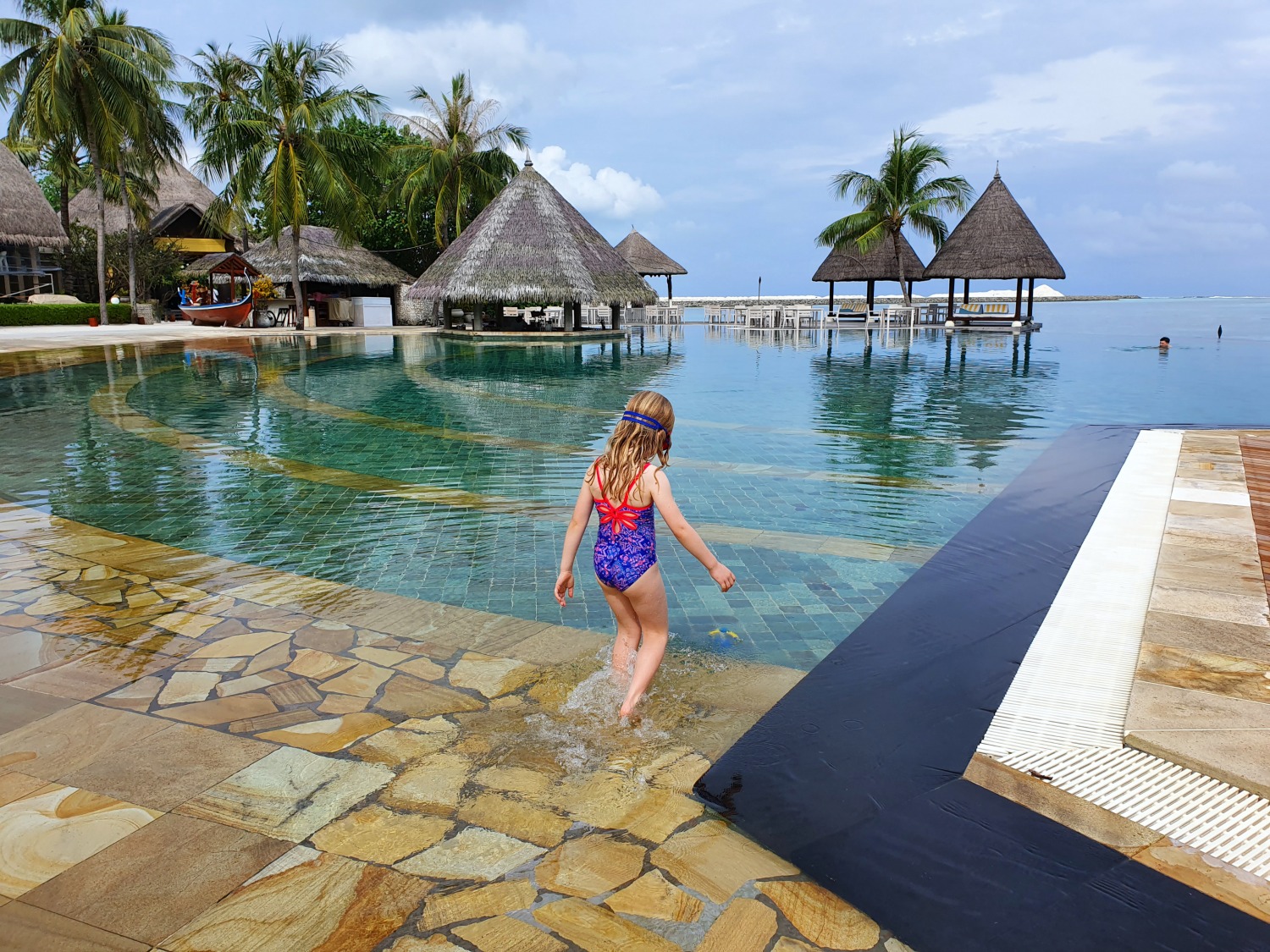 My daughter in her ecolast swimsuit from Zoggs stepping into the swimming pool at our resort in the Maldives (review product/press trip) - my October travel best buys and highlights