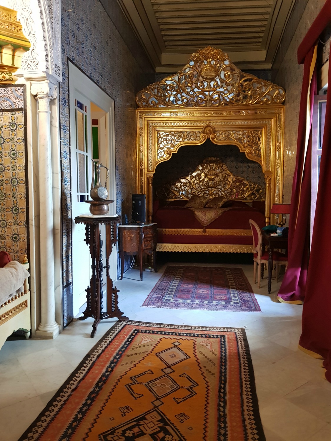 A view along Kheireddin Pacha grand historic suite at Palais Bayram, with its canopy beds under a gold arch - my Palais Bayram review